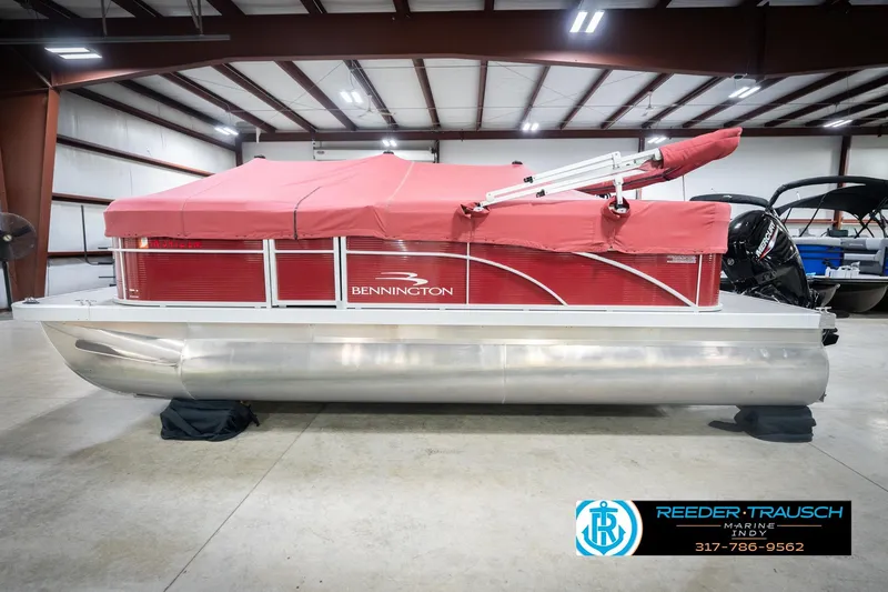 Slide: The Image of 2023 Bennington 20 SV pontoon boat with red cover in a showroom. - 57
