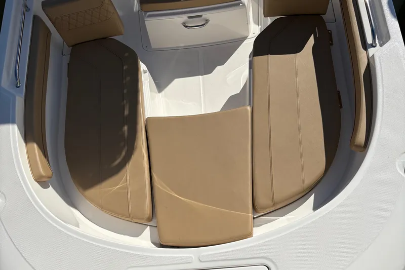 Slide: The Image of 2025 Trophy T22CC boat interior with tan cushioned seating and storage compartment. - 2
