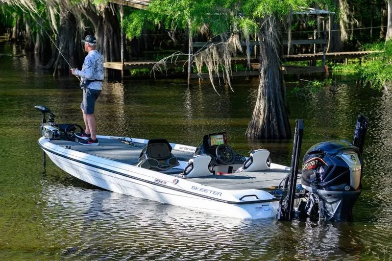 Slide: The Image of Manufacturer Provided Image: Man fishing on a 2026 Skeeter ZXE21 boat in a scenic lake setting. - 7