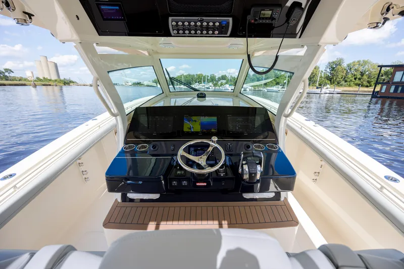 Slide: The Image of 2019 Scout 420 LXF boat roof with fishing rod holders against blue sky. - 34