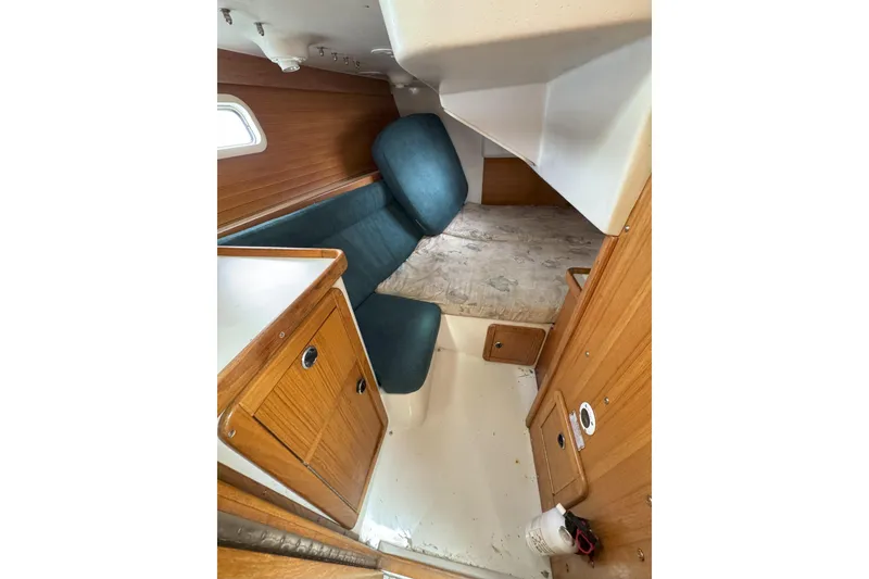 Slide: The Image of 1999 Catalina 34 MkII cabin interior with wood paneling and blue seating. - 13