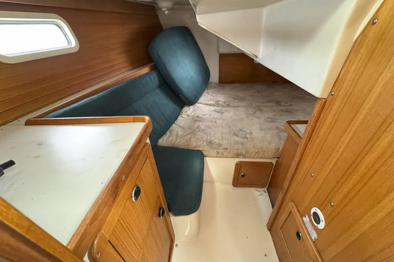 Slide: The Image of Interior of a 1999 Catalina 34 MkII sailboat, featuring cozy cabin space and wooden cabinetry. - 14