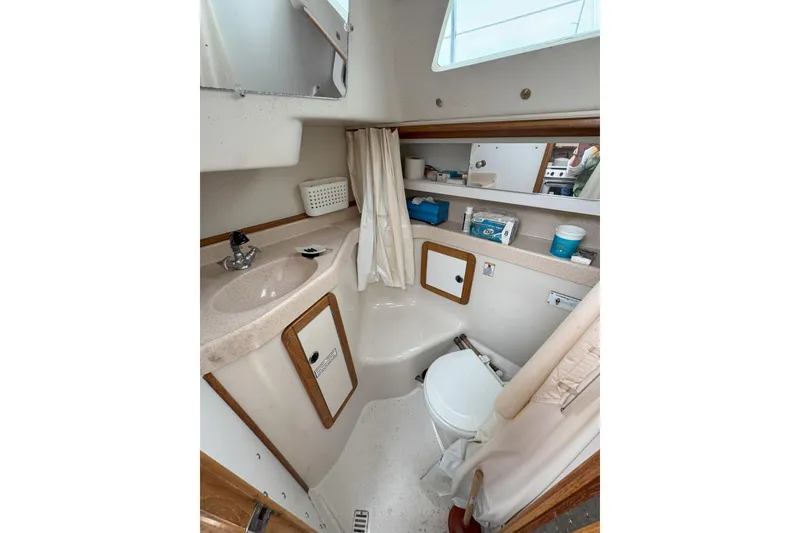 Slide: The Image of 1999 Catalina 34 MkII sailboat bathroom with sink, toilet, and storage. - 15