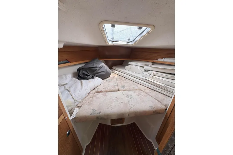 Slide: The Image of 1999 Catalina 34 MkII cabin interior with bed, cushions, and wooden accents. - 17