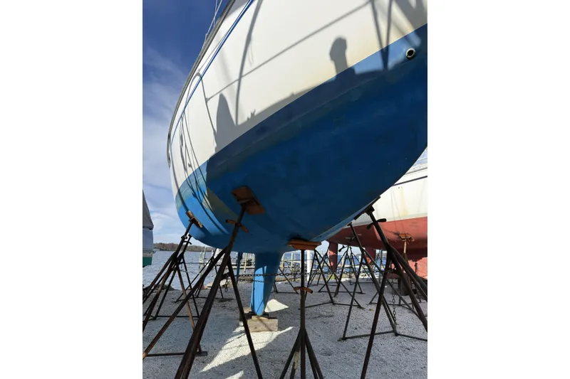 Slide: The Image of 1999 Catalina 34 MkII sailboat on stands, blue hull, outdoor storage. - 23