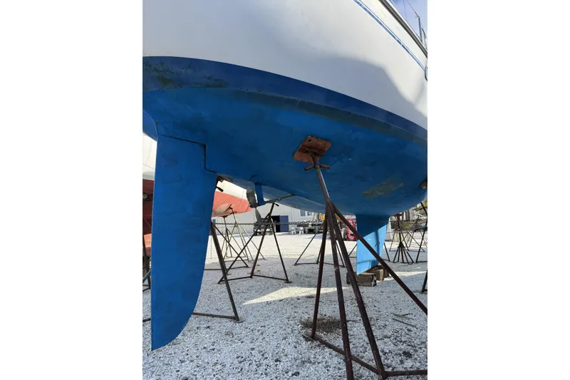 Slide: The Image of 1999 Catalina 34 MkII sailboat hull on stands, blue and white exterior. - 24