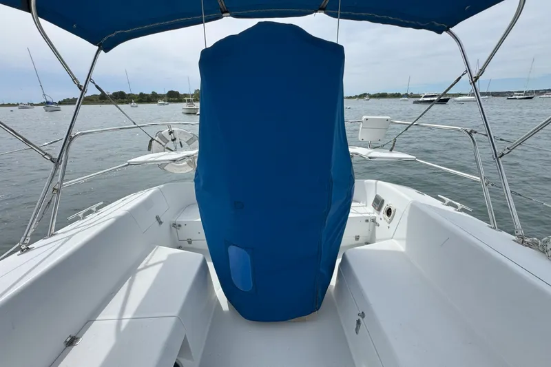 Slide: The Image of 1999 Catalina 34 MkII sailboat cockpit with blue cover, moored in a scenic harbor. - 4