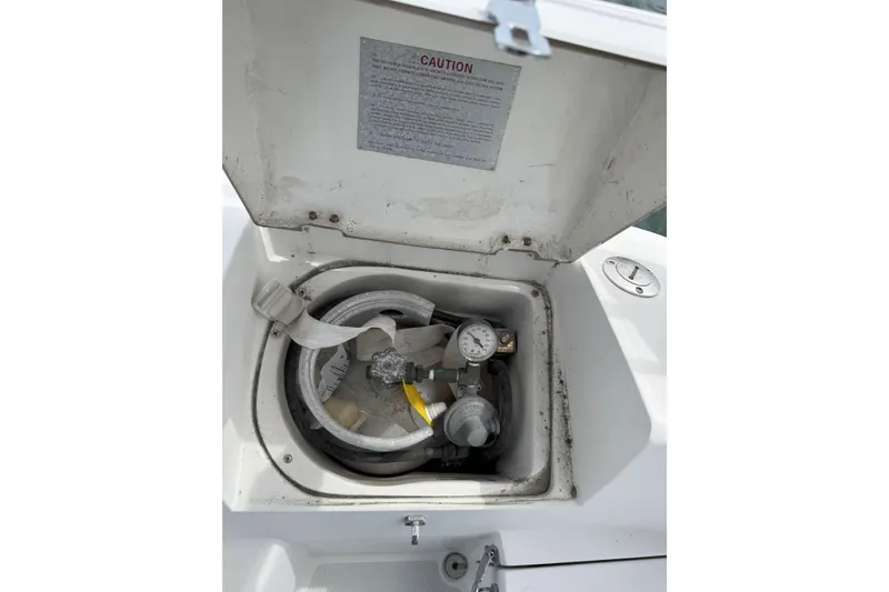 Slide: The Image of Open compartment on 1999 Catalina 34 MkII sailboat showing gas regulator and hose. - 6