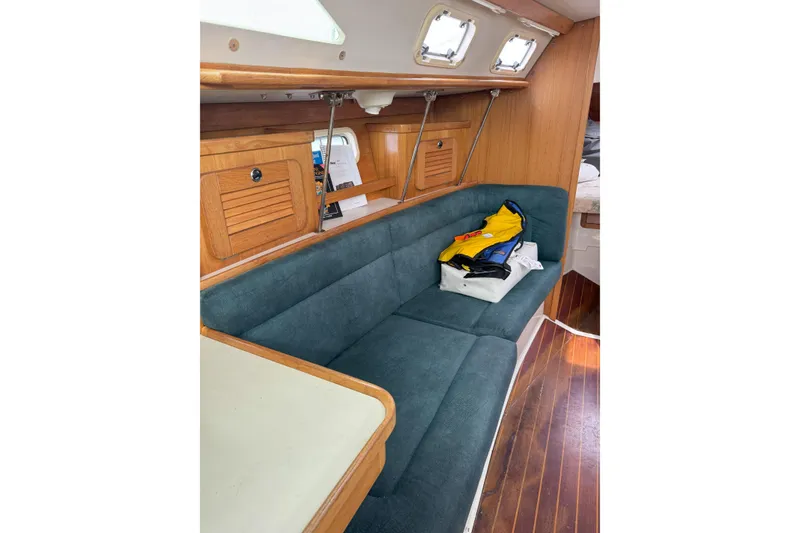 Slide: The Image of Interior of 1999 Catalina 34 MkII sailboat with teal seating and wooden cabinetry. - 9