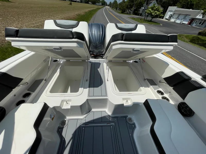 Slide: The Image of 2024 Chaparral 250 OSX boat with open storage compartments and seating. - 35