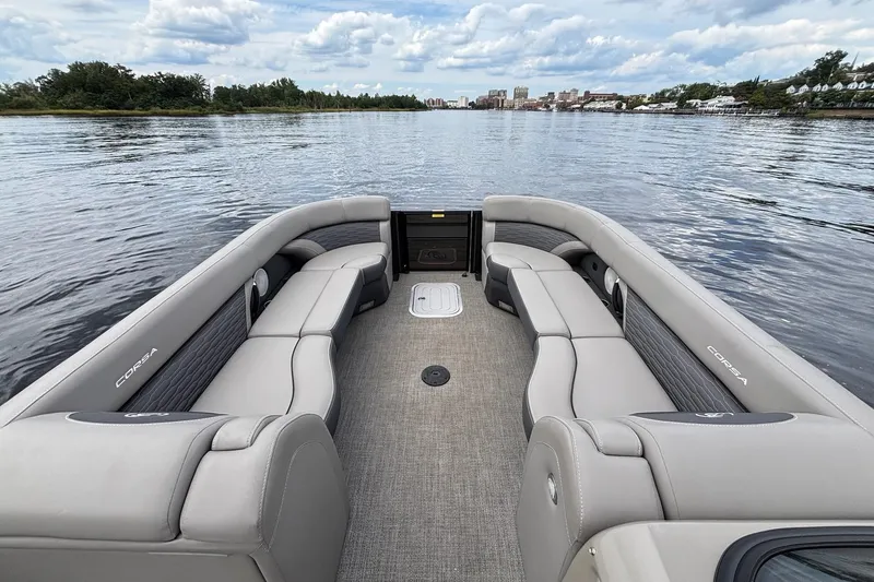 Slide: The Image of 2023 Barletta Corsa 25U pontoon boat interior with spacious seating on a calm lake. - 11