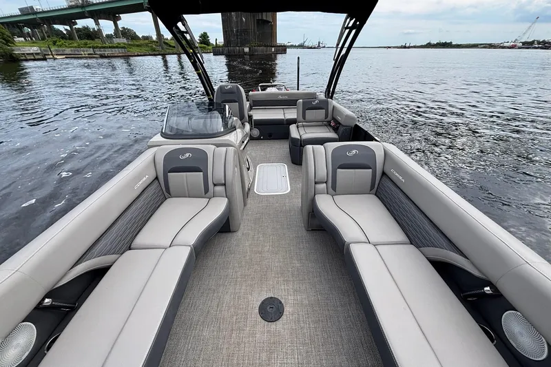 Slide: The Image of 2023 Barletta Corsa 25U pontoon boat interior with luxurious seating on a calm waterway. - 12