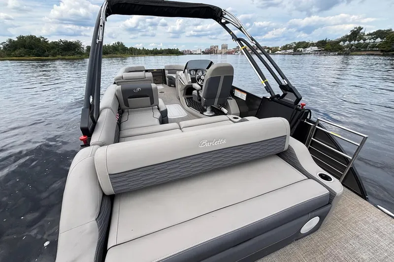 Slide: The Image of 2023 Barletta Corsa 25U pontoon boat on a scenic lake with plush seating. - 14