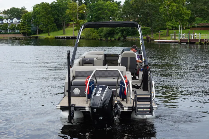 Slide: The Image of 2023 Barletta Corsa 25U pontoon boat on a serene lake with lush greenery. - 5