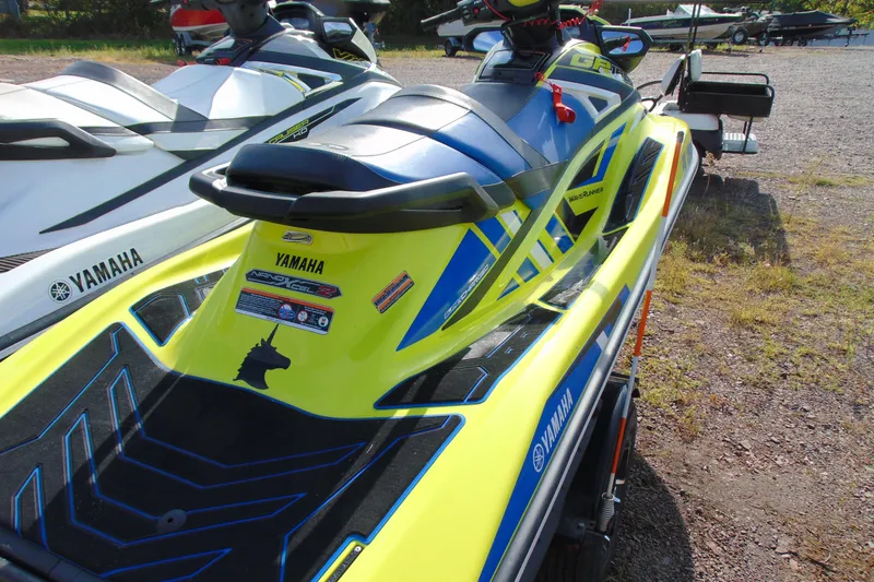 Slide: The Image of 2020 Yamaha WaveRunner GP1800R SVHO in vibrant yellow and blue, parked on gravel. - 4