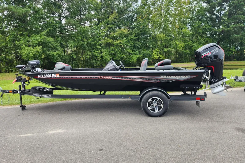 The Image of 2023 Ranger RT188P boat on trailer, parked on road with forest background. - 0