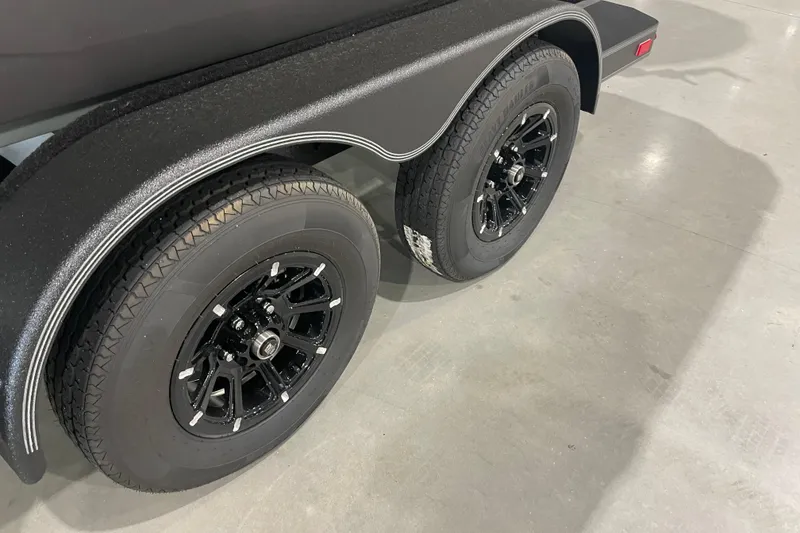 Slide: The Image of 2026 Skeeter ZXE20 trailer with black wheels on a concrete floor. - 2