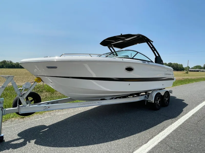 Slide: The Image of 2024 Chaparral 250 OSX boat on a trailer, parked on a road. - 2