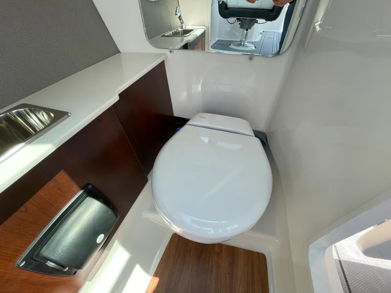 Slide: The Image of 2024 Chaparral 250 OSX boat interior bathroom with toilet and sink. - 32