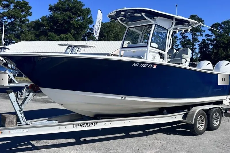 Slide: The Image of 2021 Sportsman Heritage 251 Center Console boat on trailer, parked outdoors. - 1