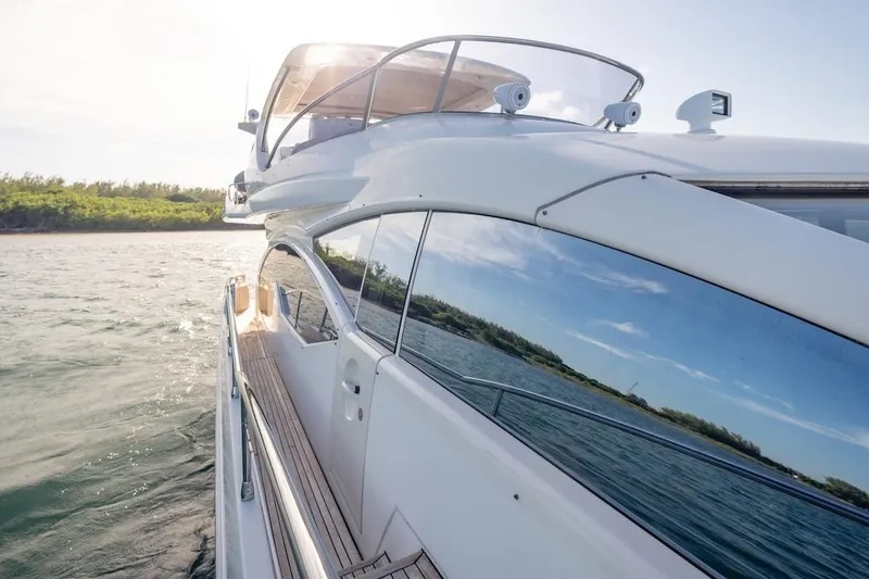 Slide: The Image of 2012 Azimut Evolution yacht cruising on serene waters, reflecting clear skies. - 25