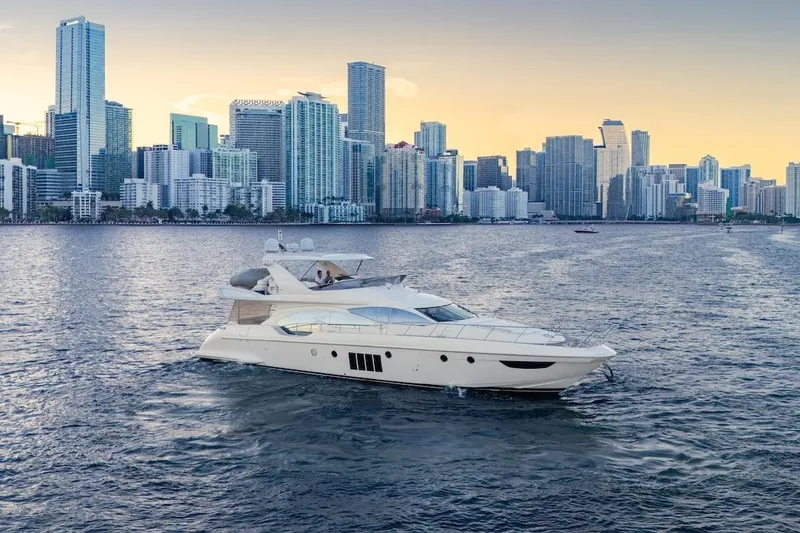 Slide: The Image of Luxury 2012 Azimut Evolution yacht cruising near a city skyline at sunset. - 5