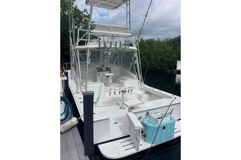 Slide: The Image of 1994 Luhrs 32 Open boat docked, featuring spacious deck and fishing equipment. - 2