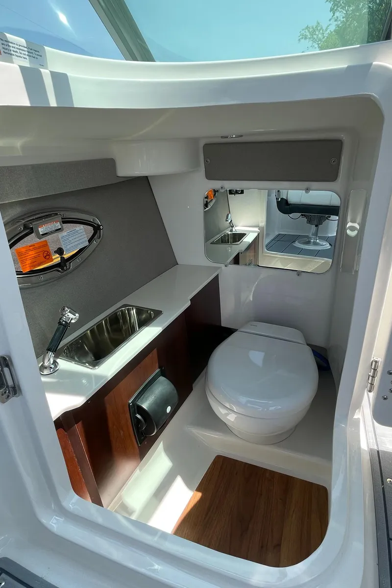 Slide: The Image of 2024 Chaparral 250 OSX boat interior bathroom with toilet and sink. - 32