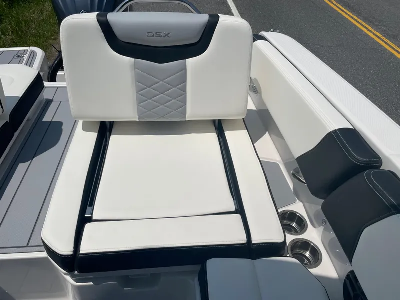 Slide: The Image of 2024 Chaparral 250 OSX boat interior with white and black seating and cup holders. - 38