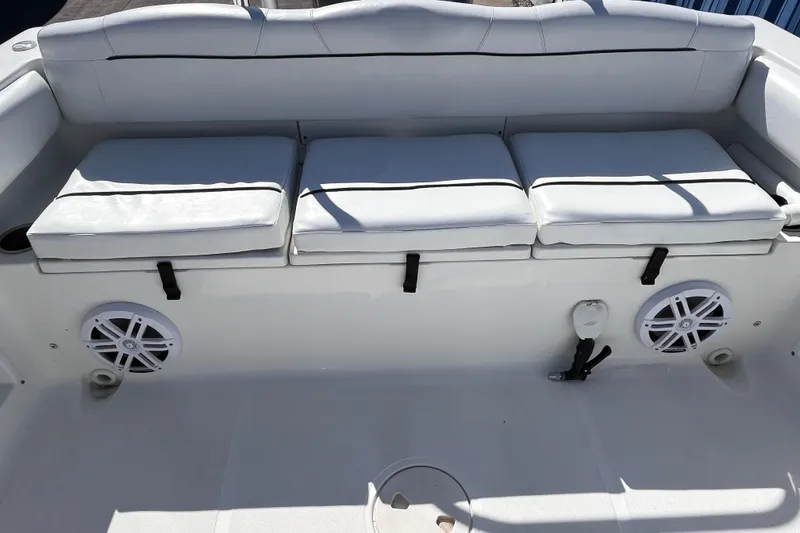 Slide: The Image of 2015 Sea Hunt Ultra 234 boat interior with cushioned seating and speakers. - 5