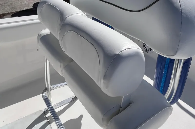 Slide: The Image of 2015 Sea Hunt Ultra 234 boat seat with white upholstery and chrome accents. - 6