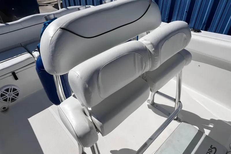 Slide: The Image of 2015 Sea Hunt Ultra 234 boat seating with white cushioned backrest and metal frame. - 7