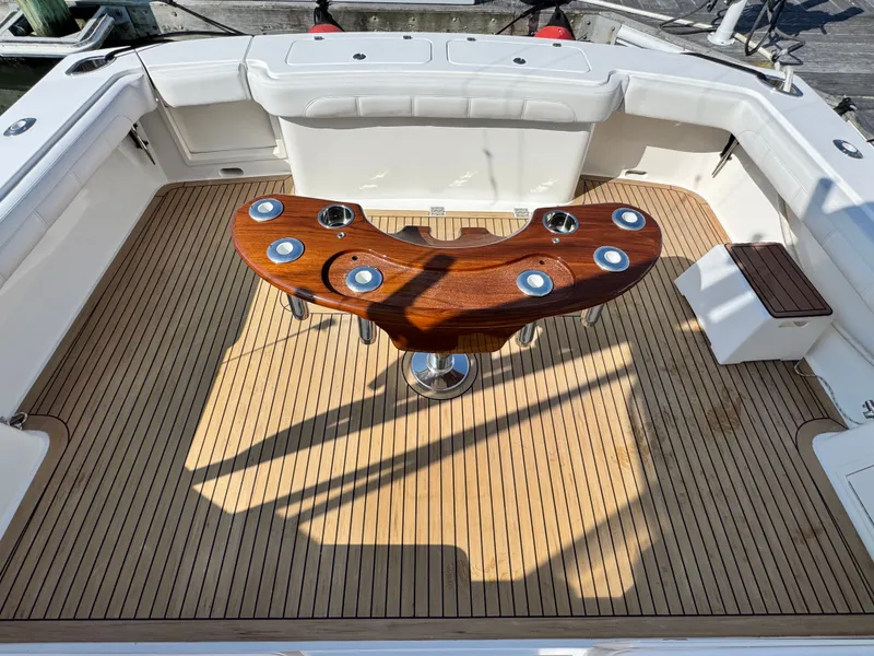 Slide: The Image of 2021 Albemarle 41 Express boat deck with wooden table and seating. - 9