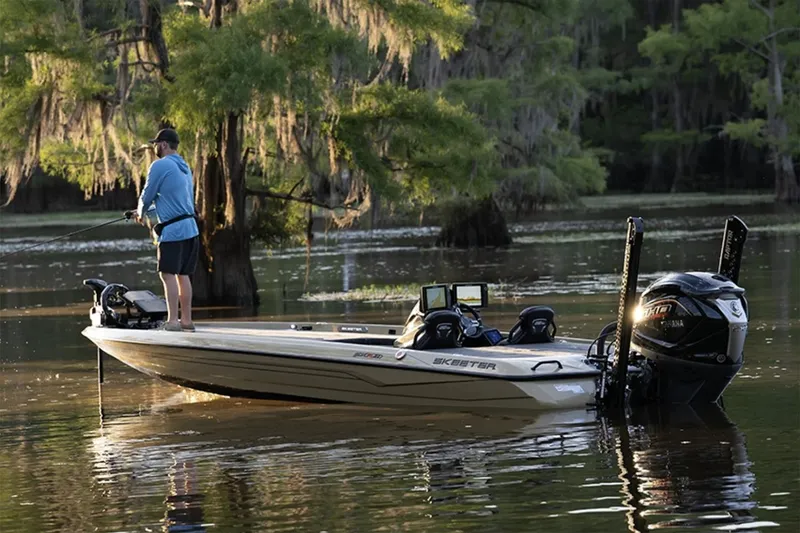 Slide: The Image of Manufacturer Provided Image: Man fishing on 2026 Skeeter FXR21 Apex boat in serene lake setting. - 15