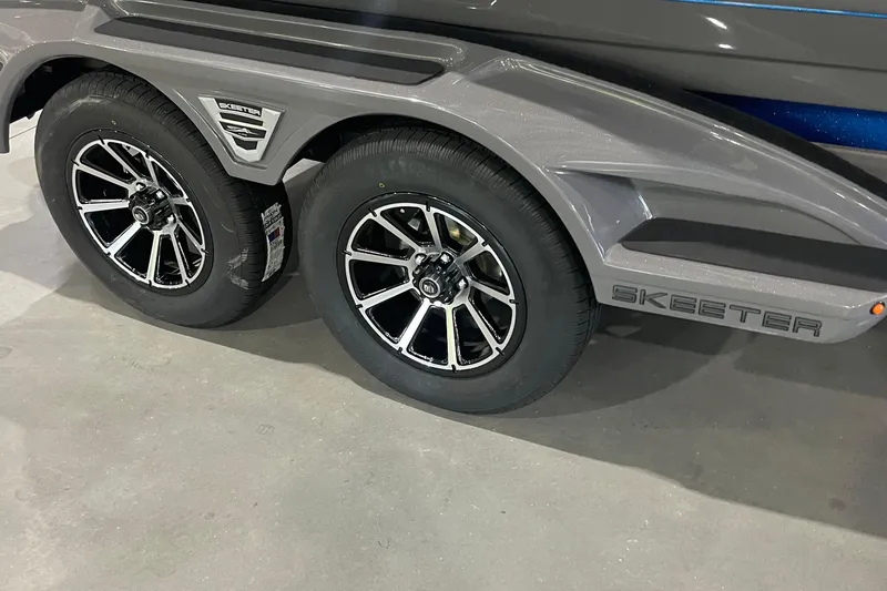 Slide: The Image of 2026 Skeeter FXR21 Apex trailer with dual black alloy wheels and sleek design. - 3