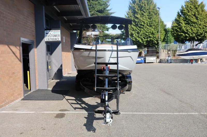 Slide: The Image of 2026 Tigé Ultré 25ZX boat on trailer outside dealership entrance. - 10