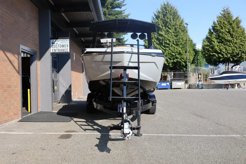 Slide: The Image of 2026 Tigé Ultré 25ZX boat on trailer outside dealership entrance. - 11