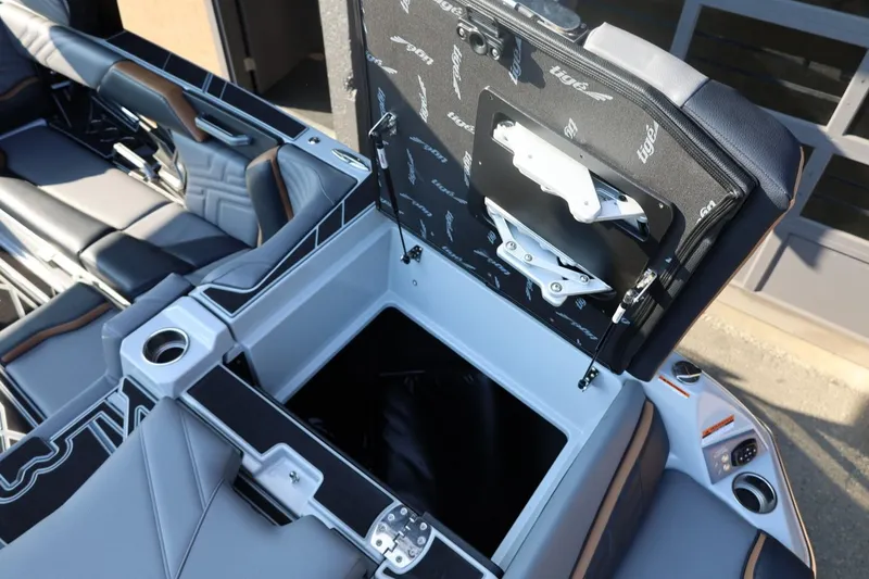Slide: The Image of 2026 Tigé Ultré 25ZX boat interior storage compartment with sleek seating and cup holders. - 22