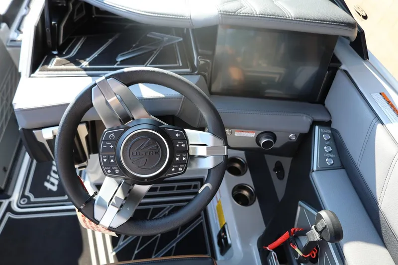Slide: The Image of 2026 Tigé Ultré 25ZX boat cockpit with modern steering wheel and control panel. - 43