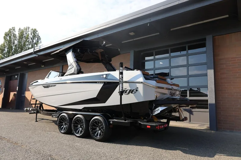 Slide: The Image of 2026 Tigé Ultré 25ZX boat on trailer outside a garage. - 6