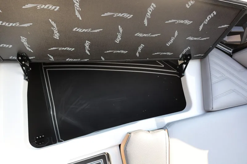 Slide: The Image of 2026 Tigé Ultré 25ZX boat storage compartment with branded interior lining. - 62
