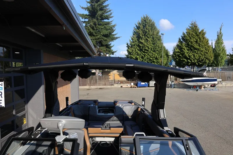 Slide: The Image of 2026 Tigé Ultré 25ZX boat with sleek design and modern features, parked outdoors. - 64