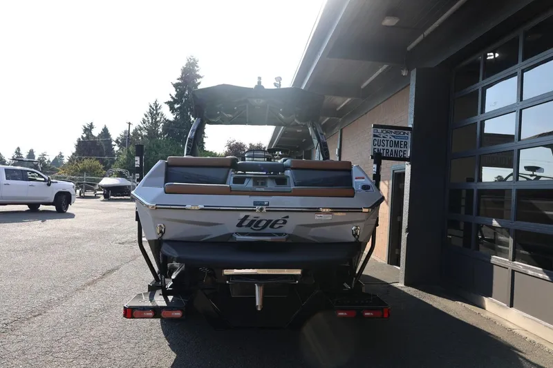 Slide: The Image of 2026 Tigé Ultré 25ZX boat parked outside dealership entrance. - 7