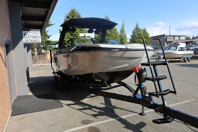 Slide: The Image of 2026 Tigé Ultré 25ZX boat on trailer outside marine dealership. - 8