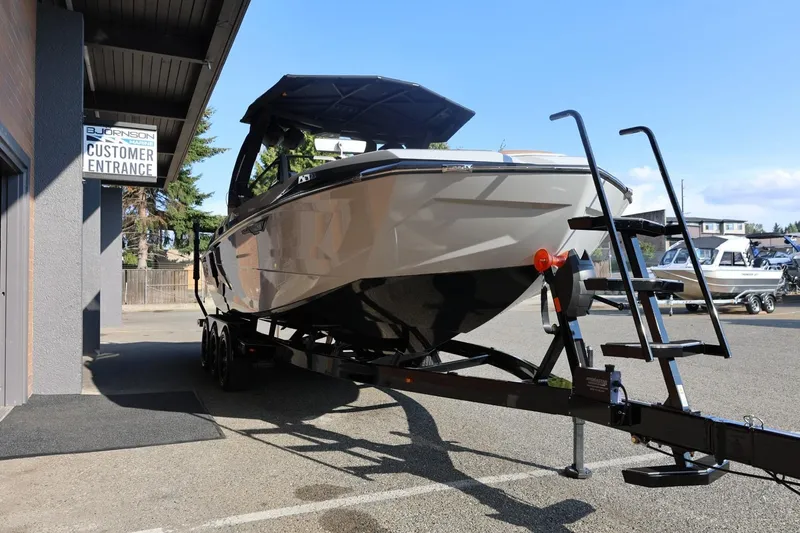 Slide: The Image of 2026 Tigé Ultré 25ZX boat on trailer outside dealership entrance. - 9