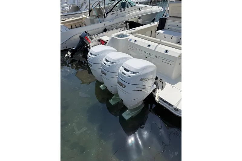 Slide: The Image of 2018 Boston Whaler 345 Conquest with triple Mercury outboard engines docked in marina. - 10