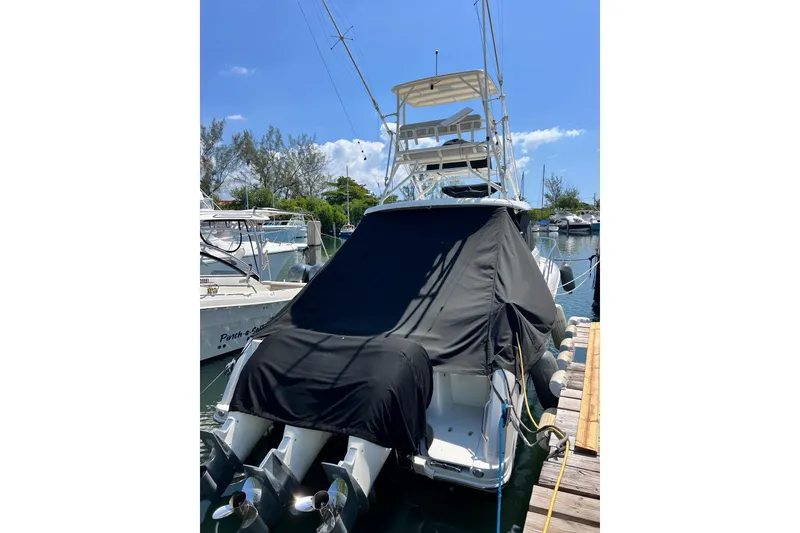 Slide: The Image of 2018 Boston Whaler 345 Conquest boat docked, covered, with dual outboard motors. - 4
