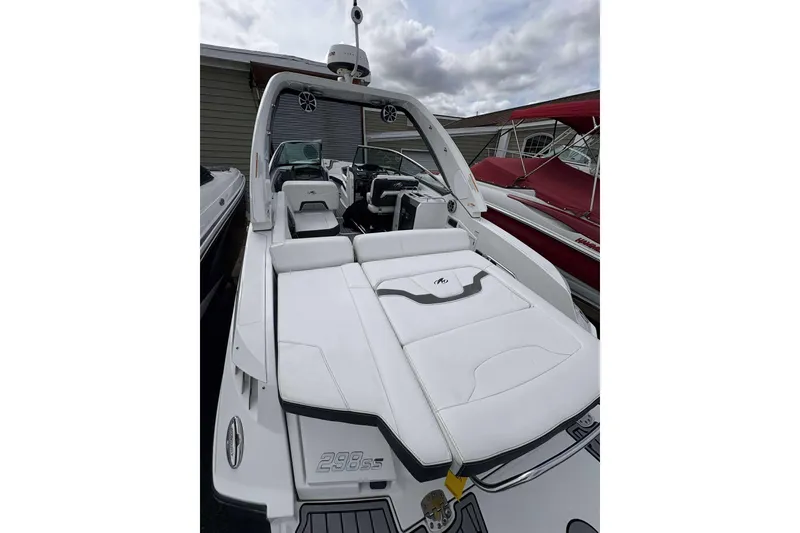 Slide: The Image of 2017 Monterey 298SS boat with white seating and sleek design, docked under cloudy skies. - 14