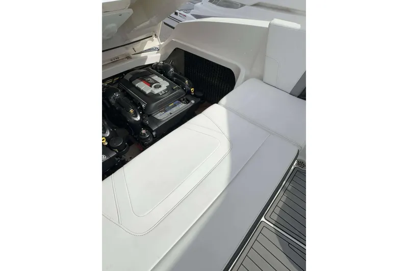 Slide: The Image of 2017 Monterey 298SS boat engine compartment with white seating and visible engine components. - 24