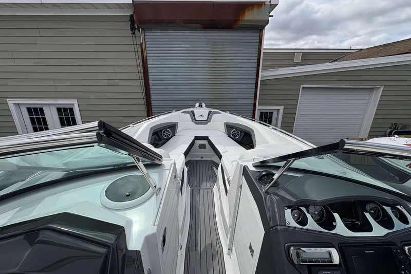 Slide: The Image of 2017 Monterey 298SS boat interior with sleek dashboard and seating, parked near a garage. - 4